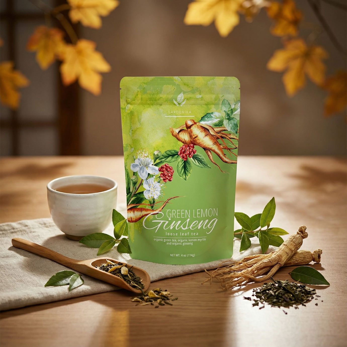 Organic Green lemon ginseng tea package on a wooden table with tea leaves and a cup.